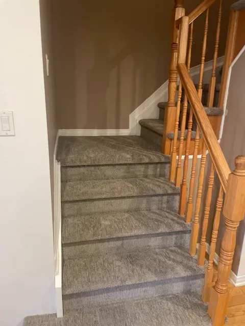 Grey plush carpet on the winder turn of an L-shaped staircase